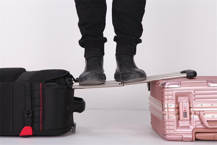 Image of a man standing on the handle of the suitcase to demonstrate its durability